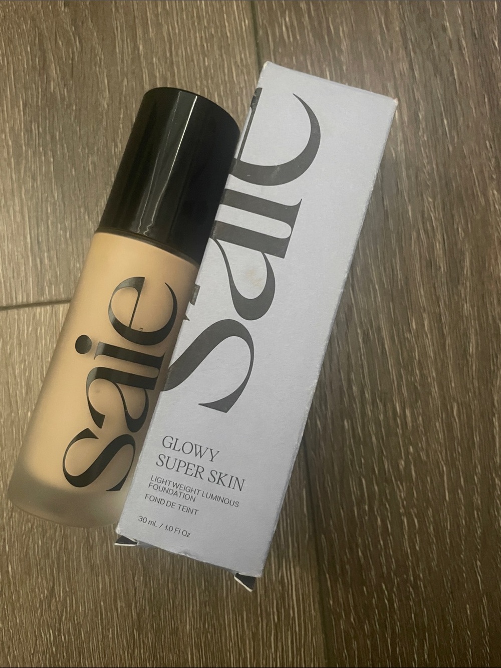 Saie Glowy Super Skin Foundation – Light Beige Bottle with Black Cap